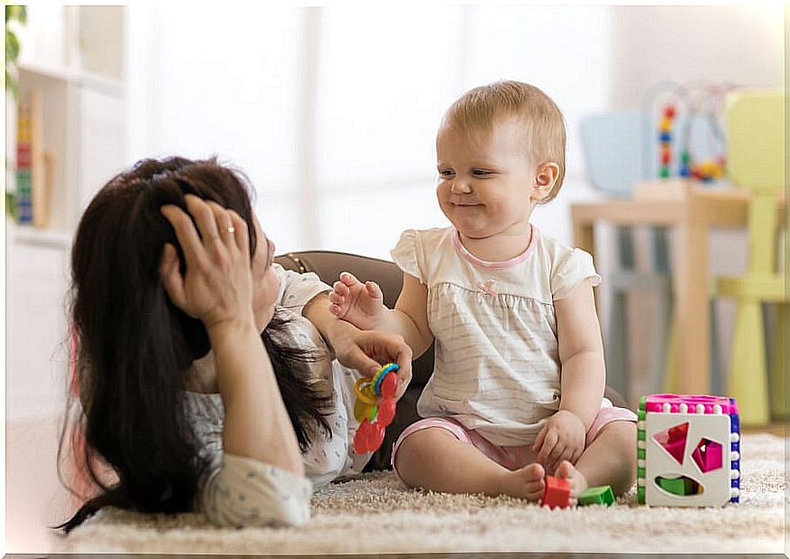 Mother plays with her baby lying on the floor doing some of the activities for your 1 year old.