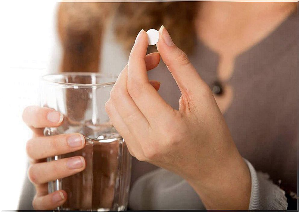 Woman with a pill in her hand: managing Crohn's disease
