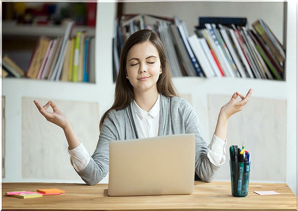Woman meditating in front of a computer
