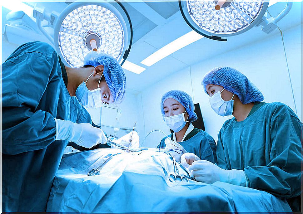 Doctors performing an operation with surgical instruments.